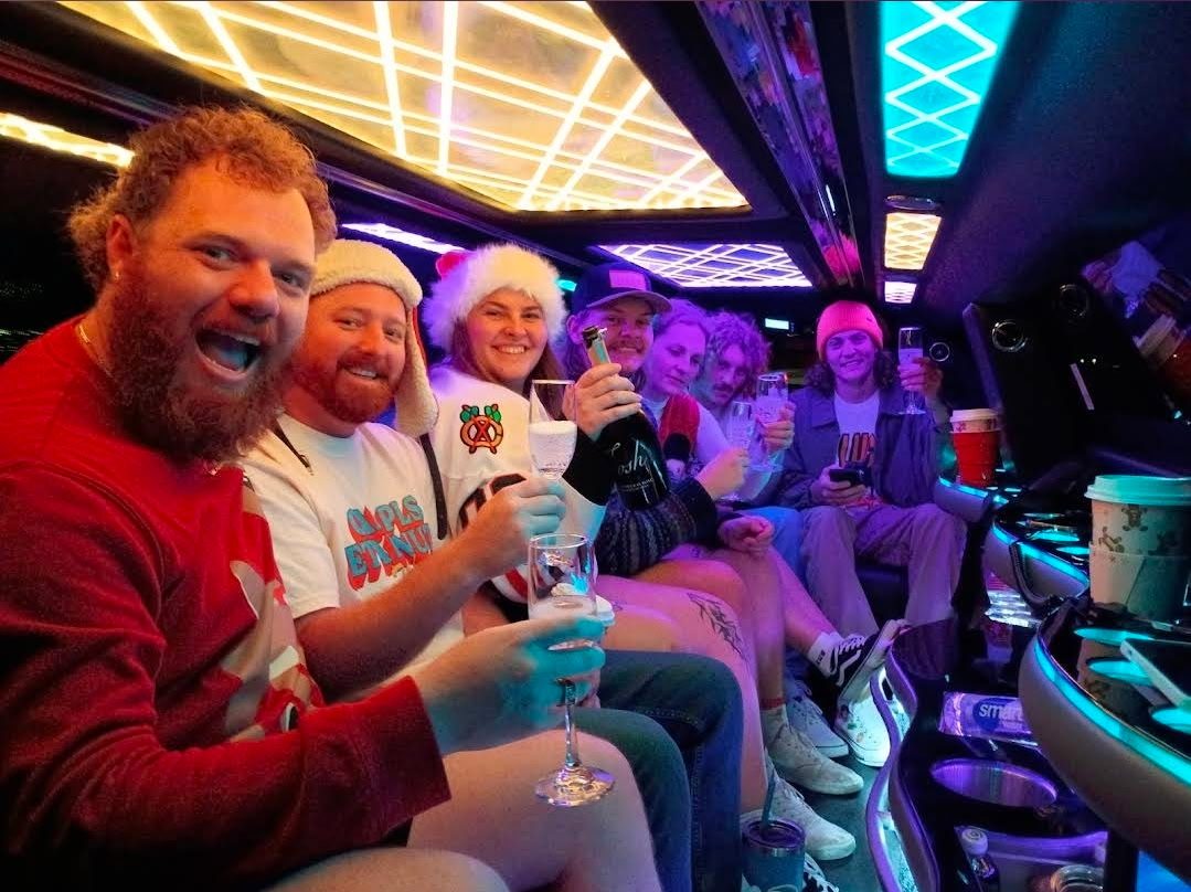 Friends toasting with champagne inside the holiday party bus