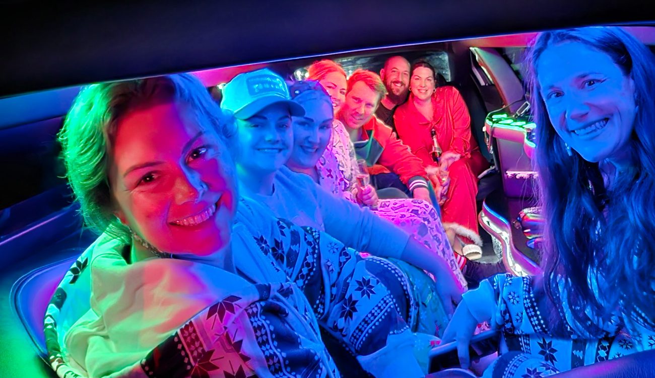 Crew in Christmas pajamas riding the lit-up party bus