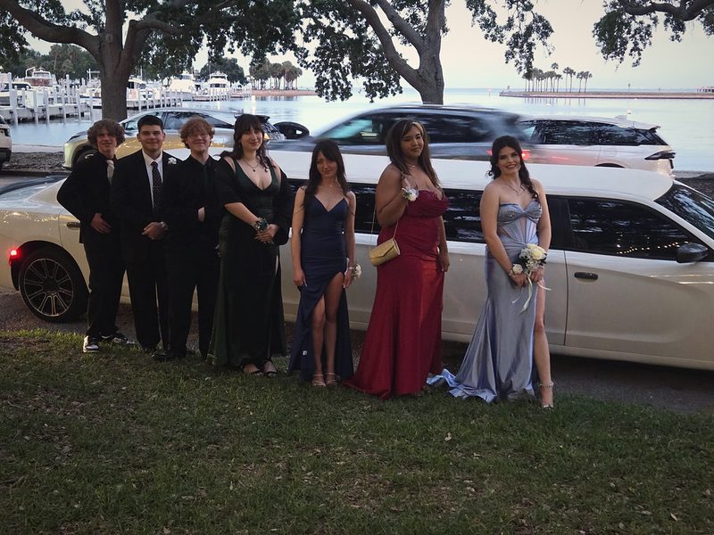 A homecoming group beside a white Big Time Limo stretch limousine on the waterfront