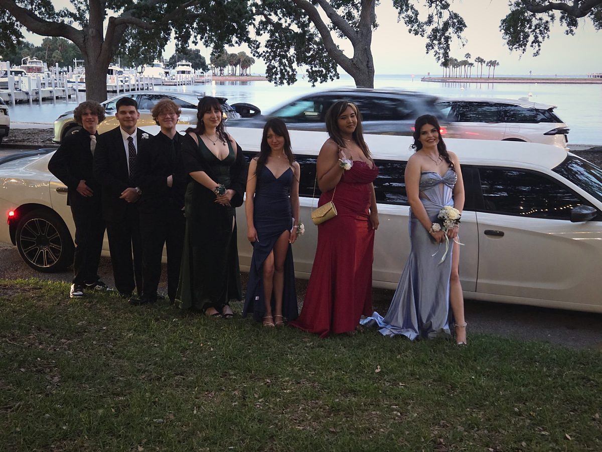 A homecoming group beside a white Big Time Limo stretch limousine on the waterfront