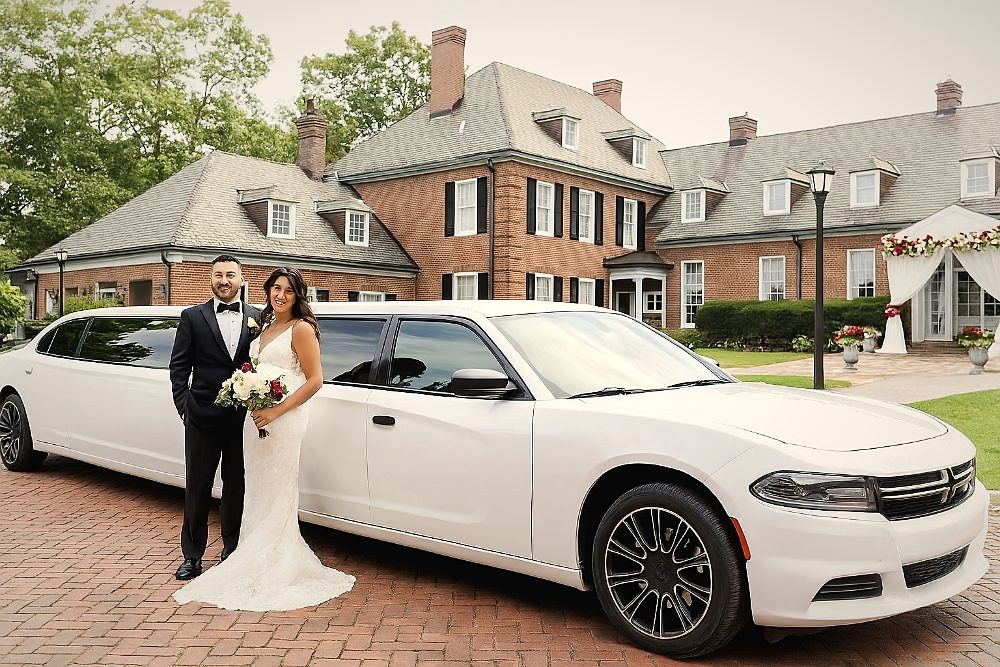 A couple with their white Big Time Limo stretch limousine on their wedding day